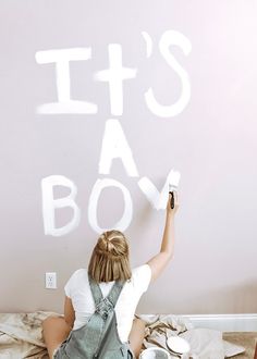 a woman is sitting on the floor and writing it's a boy