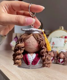 a crocheted keychain with a woman's head wearing a graduation cap