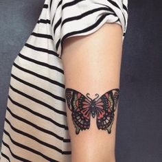 a woman's arm with a butterfly tattoo on the left side of her arm