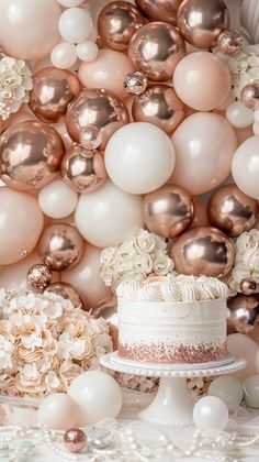 a white cake sitting on top of a table next to balloons