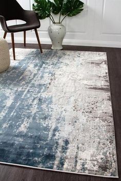 a blue and white rug in a living room with a chair next to the rug