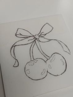 a drawing of two cherries tied with a bow on top of a piece of paper