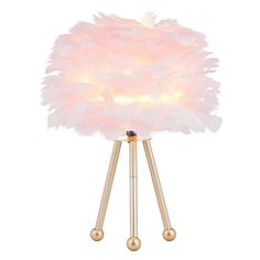 a pink lamp with wooden legs and a white feather shade on the top of it