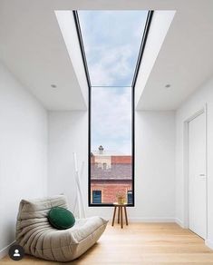 a room with a large window and a bean bag chair in the middle of it