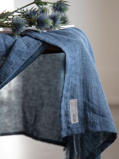 a blue scarf with some green plants on it and a mirror in the back ground