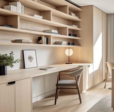 a home office with wooden shelves and white walls, along with a large window to let in natural light