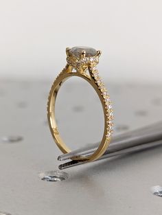 a close up of a diamond ring on top of a tabletop with drops of water around it