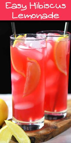 two glasses filled with lemonade sitting on top of a cutting board