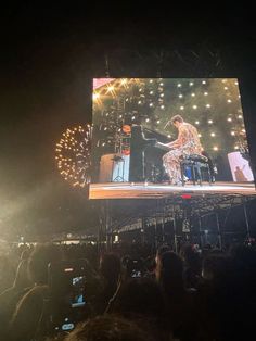 the stage is lit up with fireworks and people are standing on it, watching something