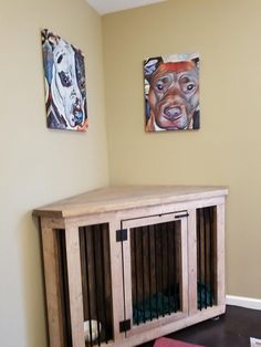 a dog kennel in the corner of a room with paintings hanging on the wall