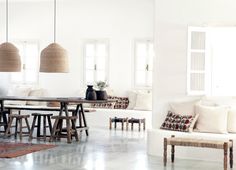 a living room filled with lots of white furniture and pillows on top of it's walls