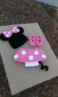 a crocheted minnie mouse hat, booties and mittens on a mat