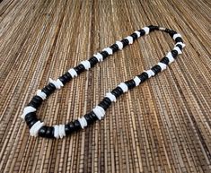 "Black and White Puka shell Necklace. Handmade with white seashell and black wooden beads 17\" Inches Around the neck Handmade Design. Necklace is Unisex Fits Most Sizes FAST SHIPPING! *First Class Mail* Visit my Etsy Shop to see more Designs! Handmade Earrings, Puka Shell Bracelets and Puka Shell Necklaces. Click here to see more designs: https://www.etsy.com/shop/FreedomLifeStyle" Black Wooden Beads Necklace For Beach, White Necklace With Black Beads For Beach, Black Round Bead Jewelry For Vacation, Black Round Beads Jewelry For Vacation, Black Round Bead Jewelry, Adjustable Black Necklace For Vacation, Handmade Black Shell Necklaces, Black Beaded Necklace For Vacation, White Wooden Beads Necklace For Vacation