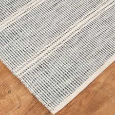 a blue and white rug sitting on top of a wooden floor next to a wood floor