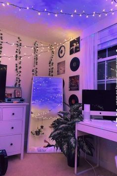 the room is decorated with string lights and pictures on the wall above the computer desk