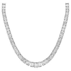 Elevate your elegance with our exquisite 19-inch Graduated Tennis Necklace, meticulously crafted in platinum and adorned with captivating emerald-cut diamonds. Each diamond is expertly set in a secure four-prong setting, showcasing their brilliance and clarity. The focal point of this masterpiece is the GIA certified H/SI2 emerald center, weighing 1.51 carats, radiating with unparalleled beauty and sophistication. With a total diamond weight of 30.04 carats, this necklace is a true statement of luxury and refinement. Indulge in timeless elegance with our Graduated Tennis Necklace, a symbol of enduring beauty and sophistication. Luxury Octagon Diamond Necklace, Luxury Silver Baguette-cut Diamond Necklace, Luxury Silver Baguette Cut Diamond Necklace, Luxury White Gold Emerald Necklace With Diamond Accents, Luxury White Gold Emerald Necklace With Brilliant Cut, Luxury White Gold Brilliant Cut Emerald Necklace, Luxury Diamond Necklace With Emerald Cut And Prong Setting, Luxury Diamond Necklace With Emerald Cut In Prong Setting, Luxury Emerald Cut Emerald Necklace With Diamond Accents