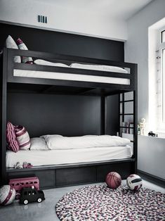 a bedroom with bunk beds, rugs and toys on the floor in front of it