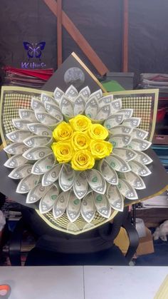 dollar bills and flowers are arranged on top of a fan made out of rolled money