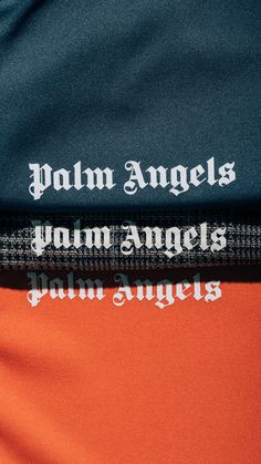 the back of an orange and blue jacket with white writing on it that says palm angels