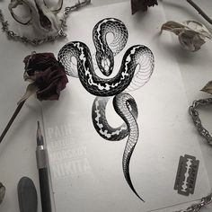 a drawing of a snake on top of a piece of paper next to some flowers