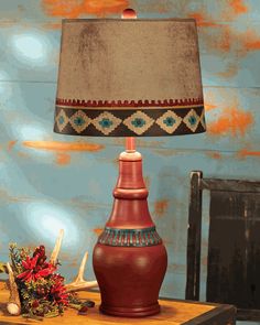 a red lamp sitting on top of a wooden table next to a brown vase with a blue base