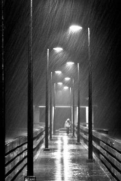 a person sitting on a bench in the rain