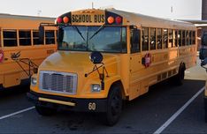 two yellow school buses parked in a parking lot