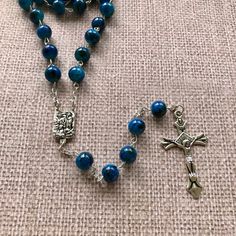 "Catholic Rosary Beads Necklace. Made and blessed in Jerusalem Holy Land Bead color: navy / multicolor Cross color - silver tone Drop length - Approximately 22\"-22.4\" ( 56-57 cm ). Approximate crucifix size -1.75\"x1\" Comes in a pouch as pictured. Silver tone metal Catholic Crucifix Cross with beautiful double sided center piece. If you have any questions, feel free to ask us. We are based in Florida and ship packages every business day very Fast and absolutely FREE! God Bless You and Your Fa Blue Spiritual Beads With Colorful Details, Blue Beaded Rosary As A Gift, Adjustable Blue Beaded Rosary, Blue Rosary With 8mm Beads For Healing, Blue Rosary With Round Beads For Healing, Blue Spiritual Rosary With Gemstone Beads, Spiritual Blue Rosary With Round Beads, Spiritual Blue Rosary With Gemstone Beads, Blue Rosary For Healing