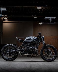 a black motorcycle parked in an empty garage