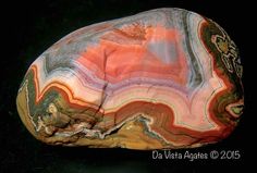 a large rock sitting on top of a black table next to a dark background with an orange and white stripe