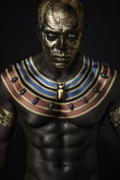 a man with gold paint on his face and chest