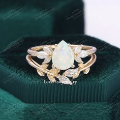 an opal and diamond ring in a green velvet box