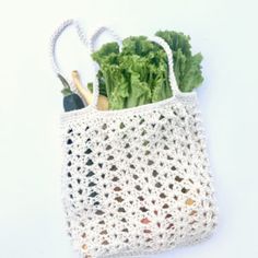 a crocheted shopping bag with vegetables in it