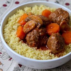 a white bowl filled with meatballs and carrots on top of couscous