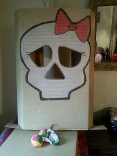 a cardboard box with a skull and bow on it