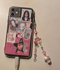 a cell phone case with some pictures on it and a keychain attached to it