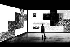 a man standing in front of an art exhibit with black and white images on the walls