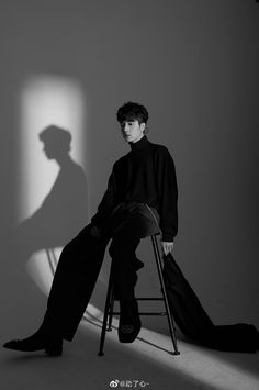 a man sitting on top of a chair next to a shadow