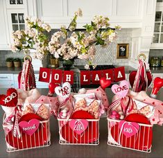 valentine's day gift baskets on a kitchen counter with flowers in vases behind them