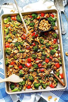 a sheet pan filled with stir fry vegetables and cashews