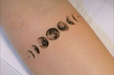 a woman's arm with phases of the moon on it