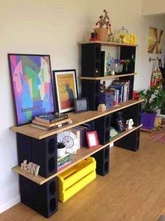 there are bookshelves and shelves in the living room with pictures on top of them