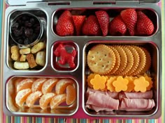 a bento box filled with fruit and crackers