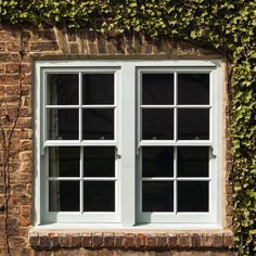 an image of a window with ivy growing on the side of it in front of a brick wall