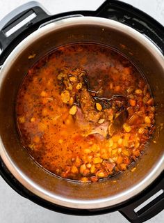 a pot filled with stew and vegetables on top of a stove burner, ready to be cooked