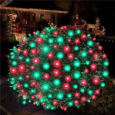 a christmas tree with lights on it in front of a house