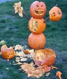 a group of pumpkins that are sitting in the grass with faces carved into them