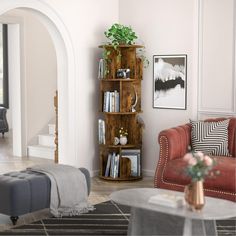 a living room filled with furniture and a book shelf next to a couch in front of a doorway