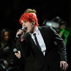 a man with red hair singing into a microphone