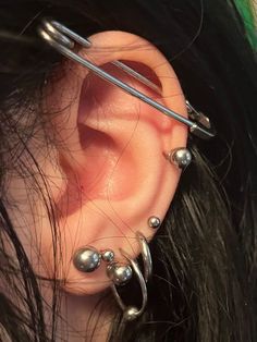 a close up of a person's ear with some piercings on top of it